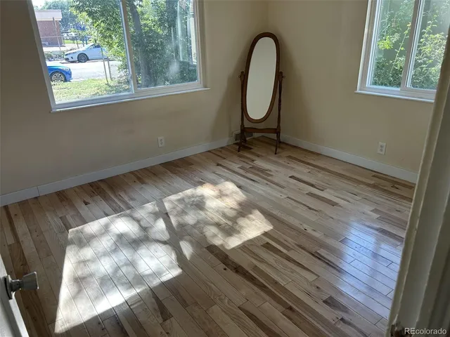a view of a room with wooden floor and windows