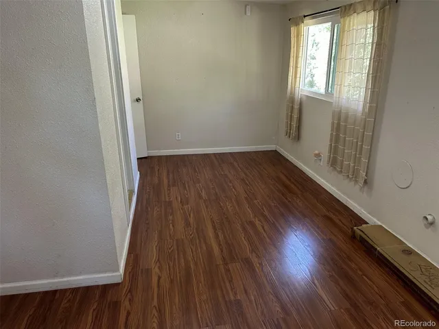 a view of a room with wooden floor and a window