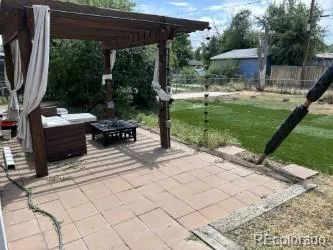 a view of backyard with a table and chairs under an umbrella