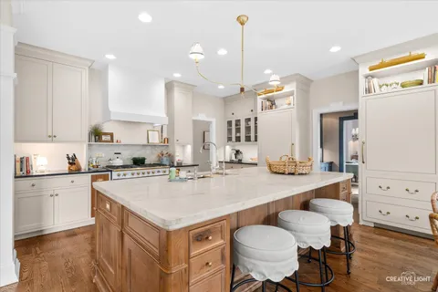 a kitchen with a sink a stove a center island and chairs