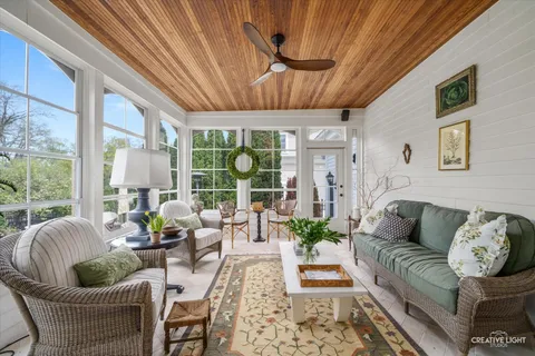 a living room with furniture fireplace and large windows