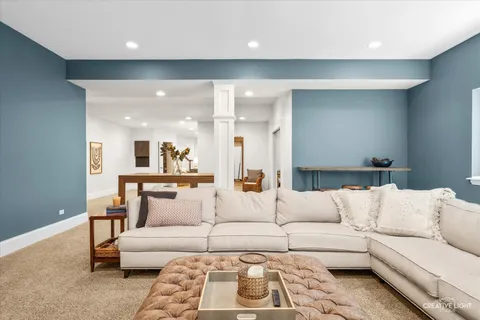 a living room with a couches and kitchen view with wooden floor