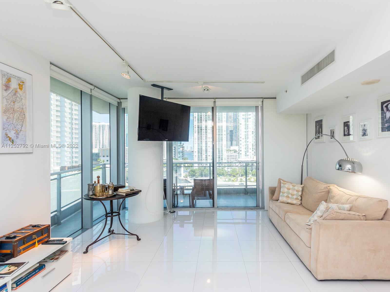 92 Southwest 3rd Street, Unit 1510 Miami, FL 33130 - Photo 12 of 90 a living room with furniture a flat screen tv and a large window