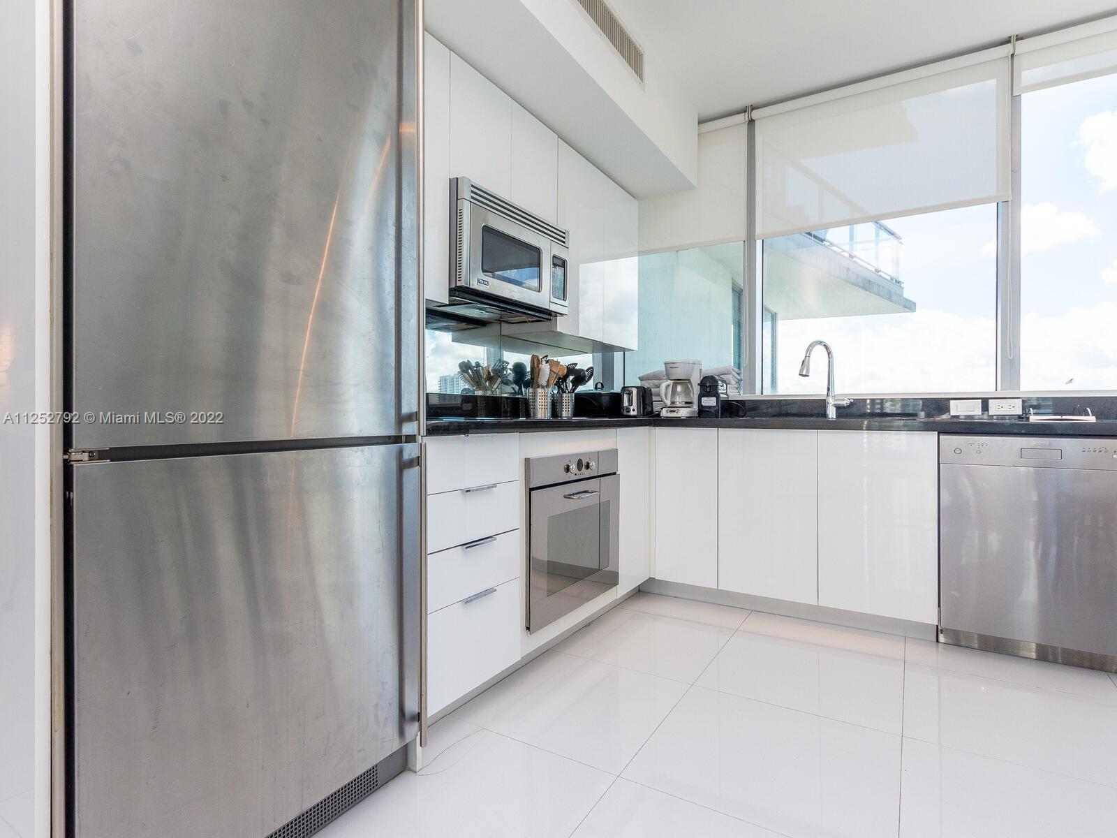 92 Southwest 3rd Street, Unit 1510 Miami, FL 33130 - Photo 17 of 90 a kitchen with white cabinets and white appliances