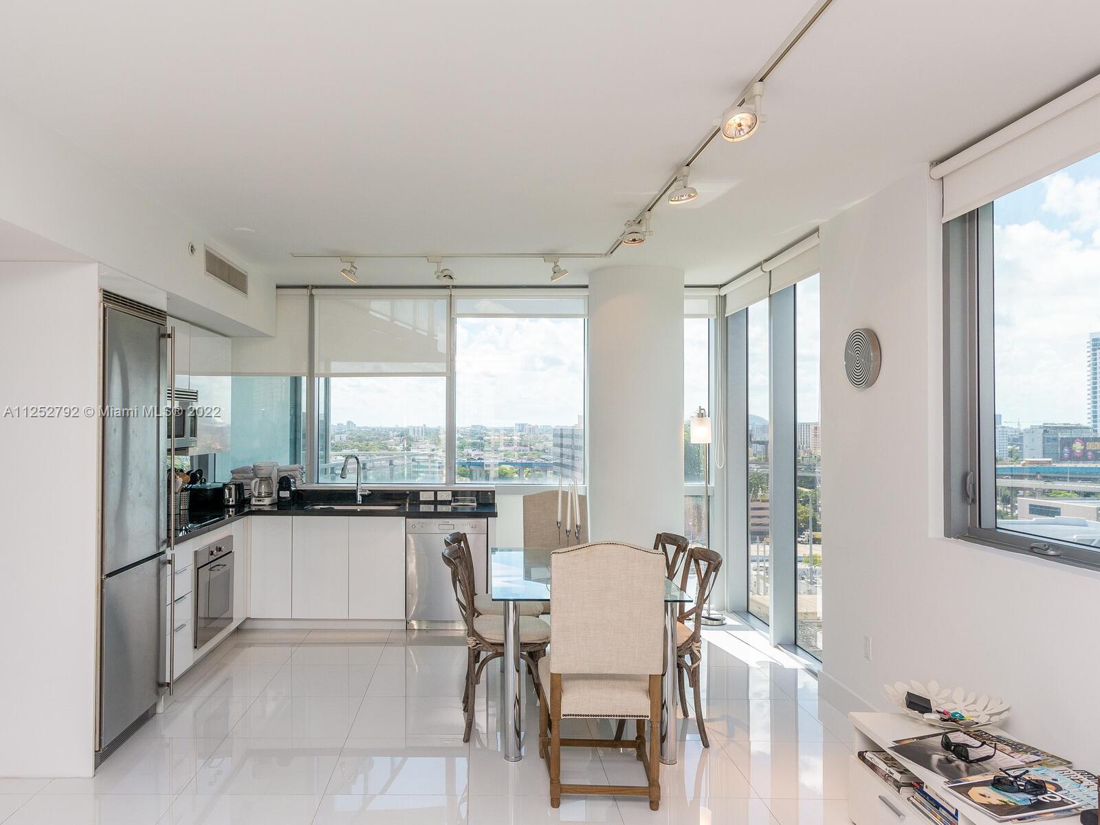 92 Southwest 3rd Street, Unit 1510 Miami, FL 33130 - Photo 20 of 90 a kitchen with a table chairs refrigerator and cabinets