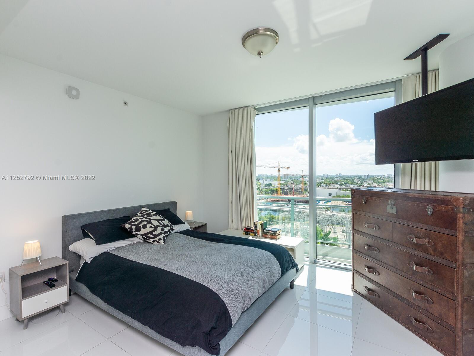 92 Southwest 3rd Street, Unit 1510 Miami, FL 33130 - Photo 23 of 90 a bedroom with a bed and large window