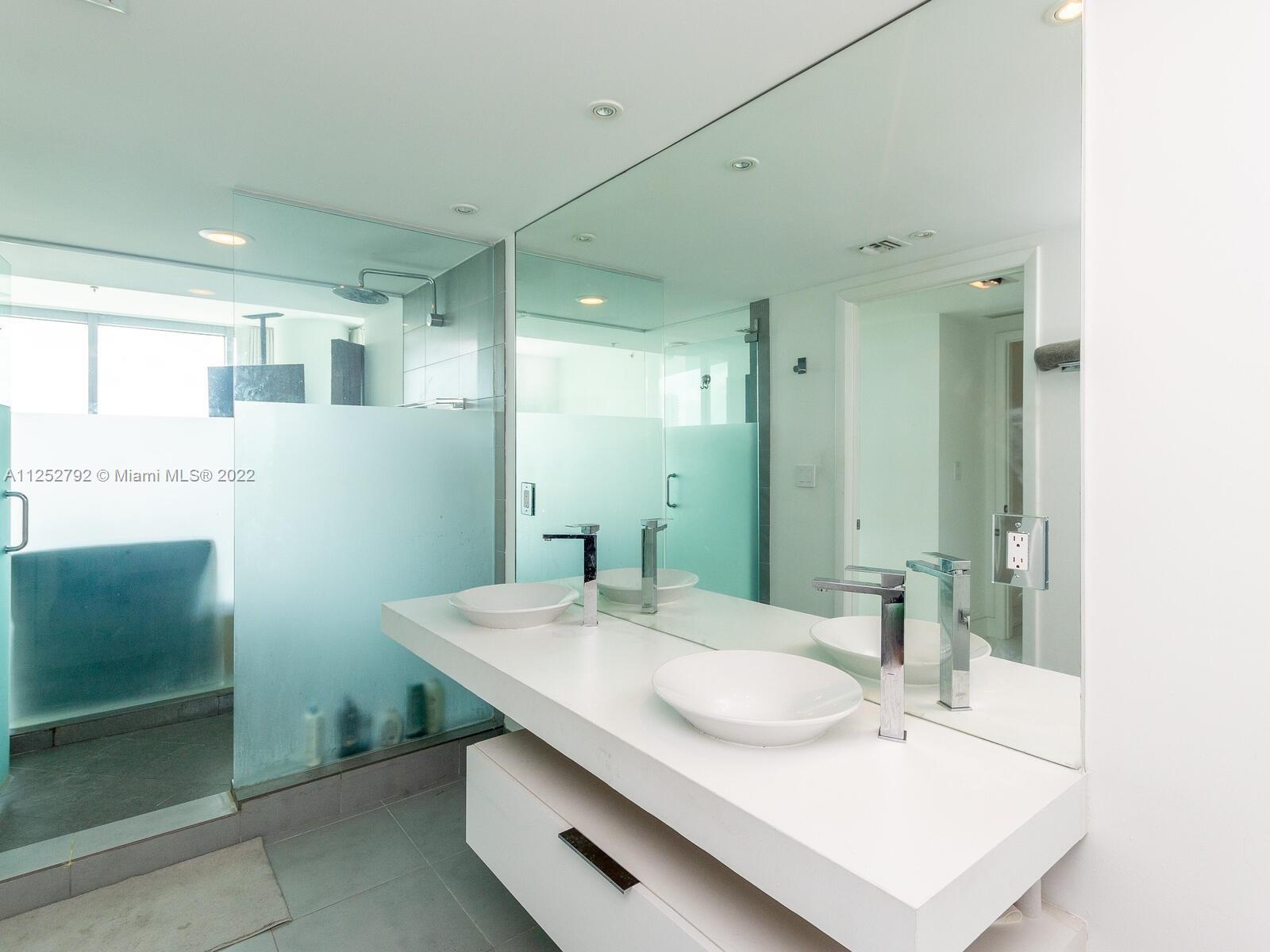 92 Southwest 3rd Street, Unit 1510 Miami, FL 33130 - Photo 28 of 90 a bathroom with a sink a mirror and a shower