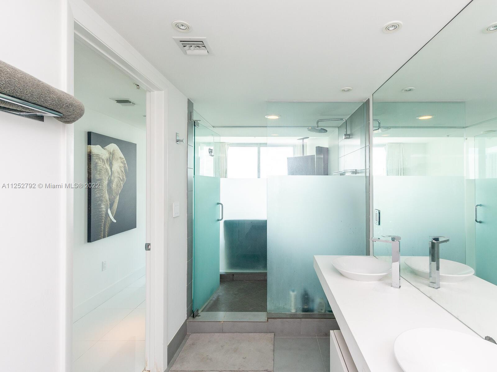 92 Southwest 3rd Street, Unit 1510 Miami, FL 33130 - Photo 29 of 90 a bathroom with a sink and mirror