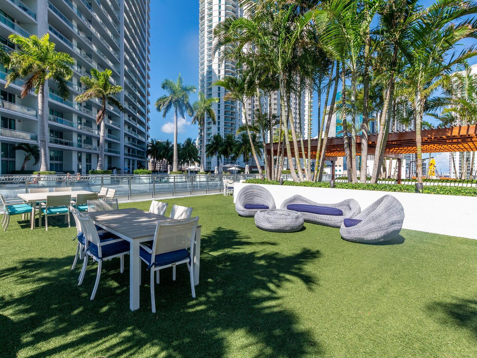 92 Southwest 3rd Street, Unit 1510 Miami, FL 33130 - Photo 67 of 90 a view of a patio with table and chairs potted plants and palm trees