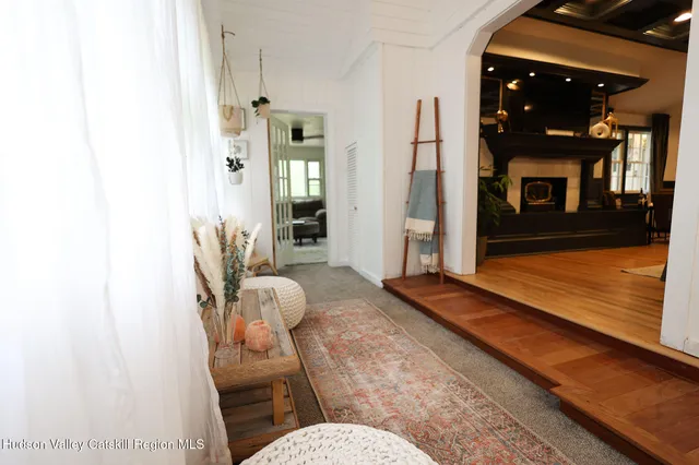 a kitchen with stainless steel appliances a sink a stove a refrigerator a dining table and chairs with wooden floor