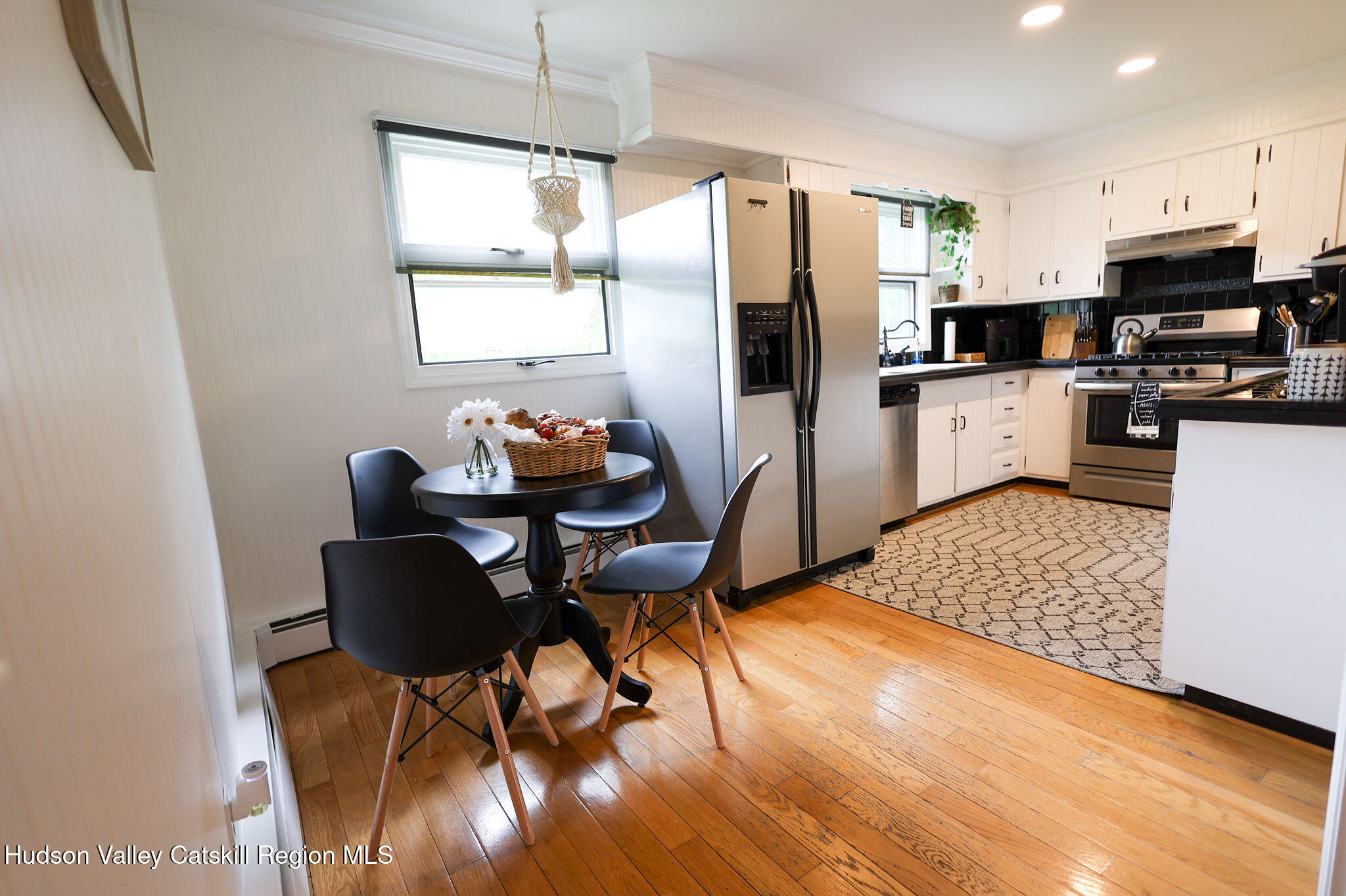 523 Mitchell Hollow Road Windham, NY 12496 - Photo 19 of 59 a kitchen with stainless steel appliances wooden floors dining table and chairs