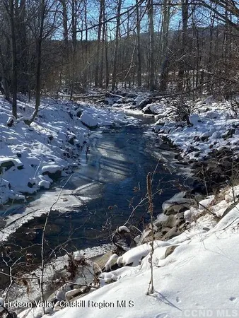 a front view of a house with garden and trees