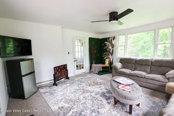 a view of a tiny house with a big yard and a large tree