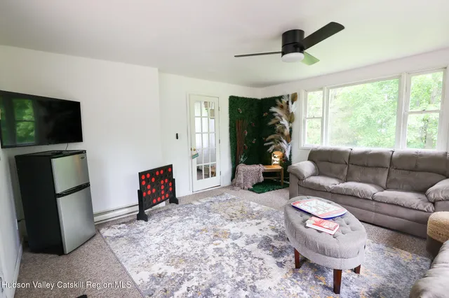 a view of a tiny house with a big yard and a large tree