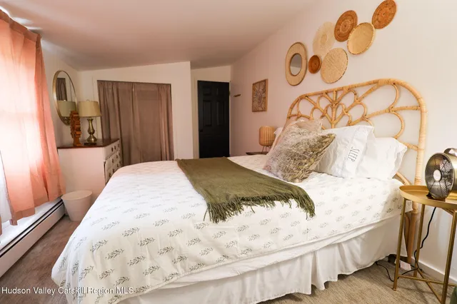 a bedroom with a bed and a painting on the wall