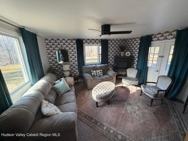 a living room with furniture a flat screen tv and a large window