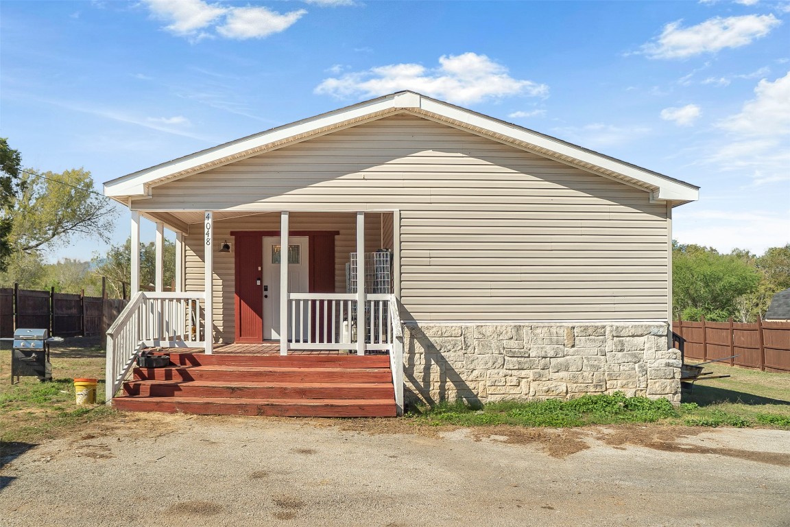 a view of a house with a small yard and a large tree