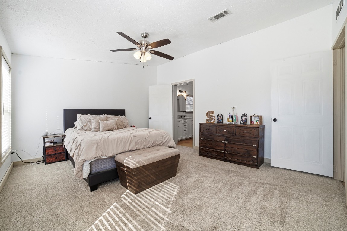 4048 Sutherland Springs Road Seguin, TX 78155 - Photo 15 of 23 a bedroom with a bed and a chandelier