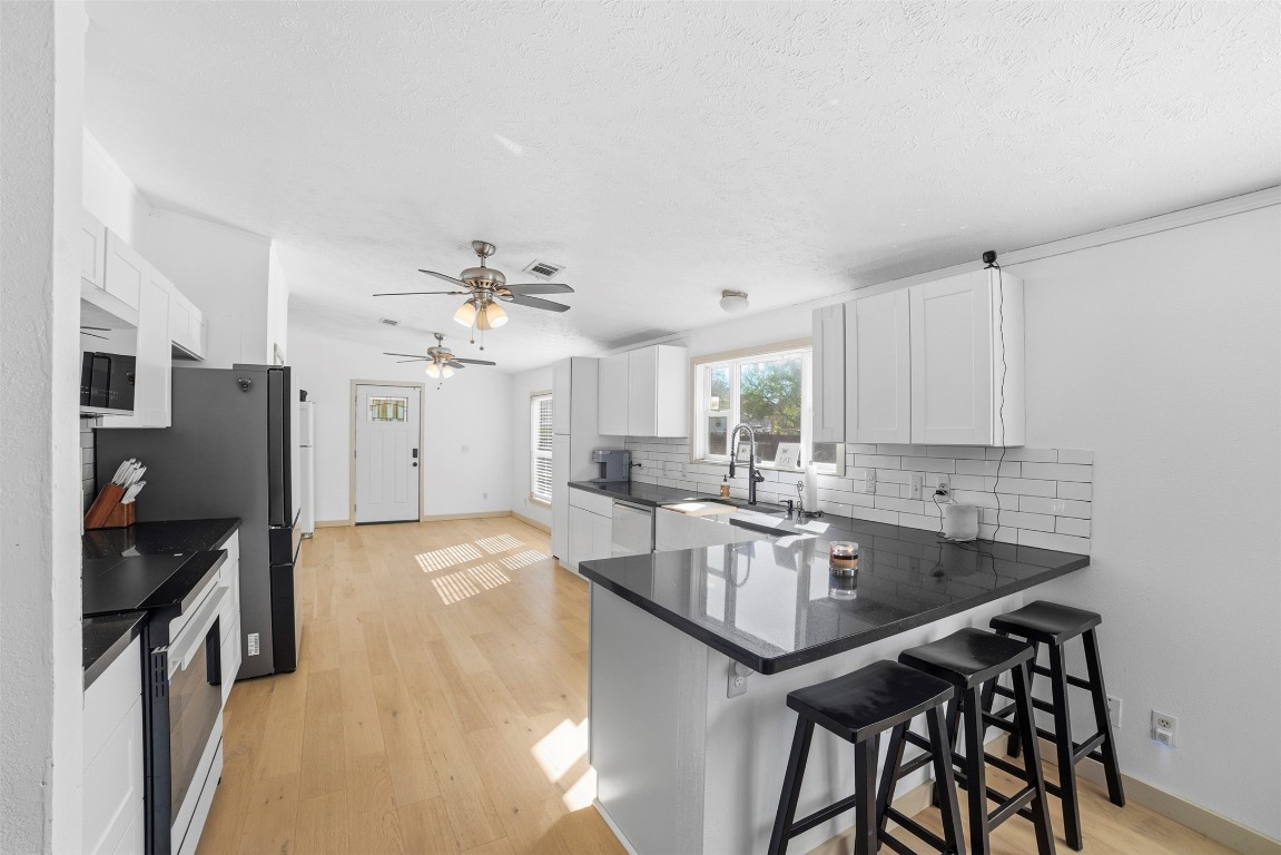 4048 Sutherland Springs Road Seguin, TX 78155 - Photo 3 of 23 a kitchen with granite countertop a table chairs stove and refrigerator