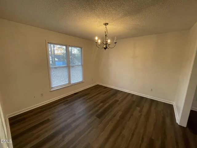 an empty room with wooden floor sink and window