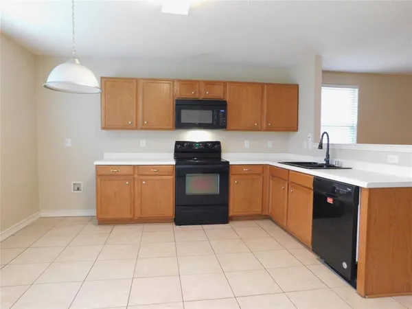 a kitchen with a sink a stove top oven and cabinets