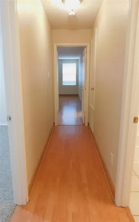 a view of a hallway with wooden floor and a living room