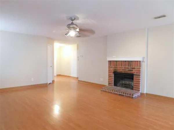 a view of an empty room with a fireplace and a window