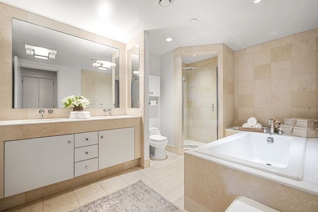 a bathroom with a sink a toilet and a large mirror