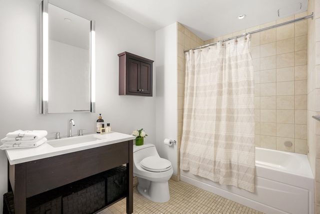 a bathroom with a double vanity sink toilet and shower