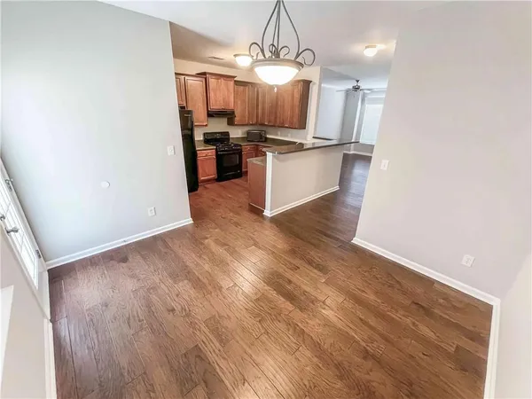 a kitchen with wooden floors and stainless steel appliances