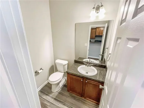 a bathroom with a sink a toilet a mirror and vanity