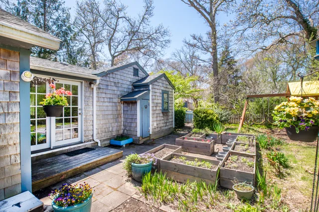 a view of a house with backyard sitting area and garden