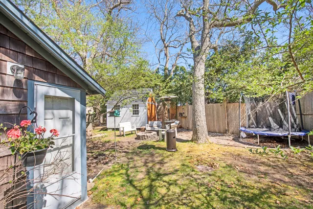 a view of a patio with table and chairs and potted plants with wooden fence