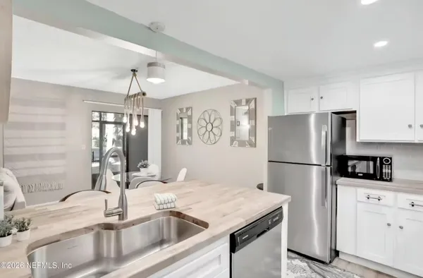 a kitchen with a sink a refrigerator and cabinets