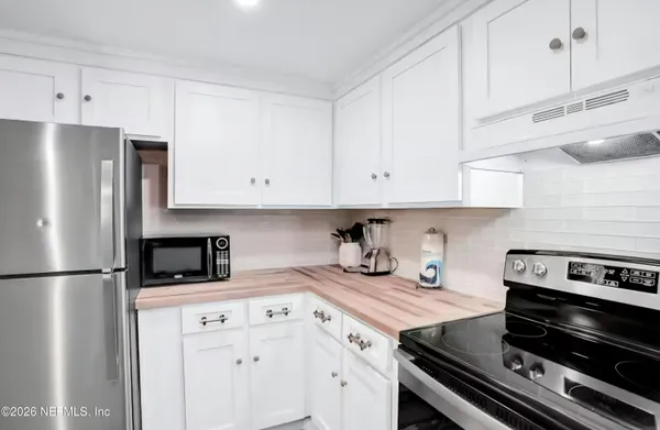 a kitchen with stainless steel appliances granite countertop a stove a refrigerator and a white cabinets
