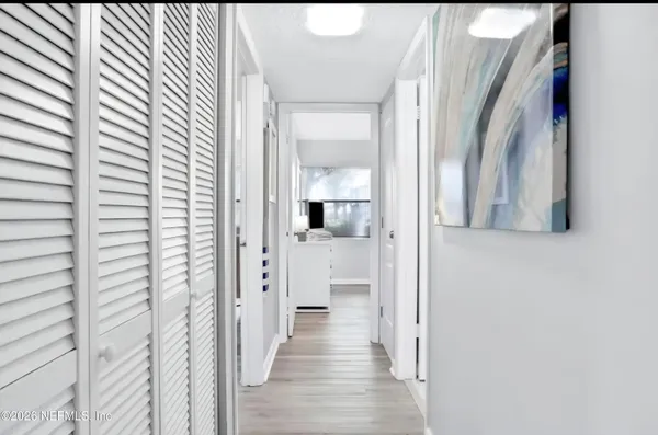a view of a hallway with wooden floor and staircase