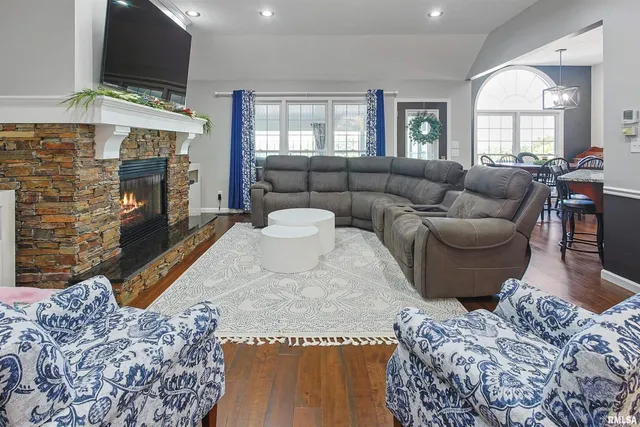 a living room with furniture a flat screen tv and a fireplace