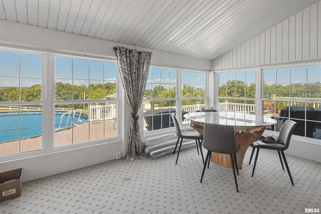 a view of a dining room with furniture large windows and wooden floor