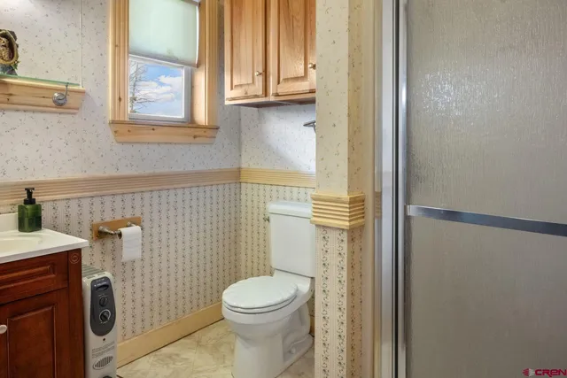 a bathroom with a toilet a sink and a window