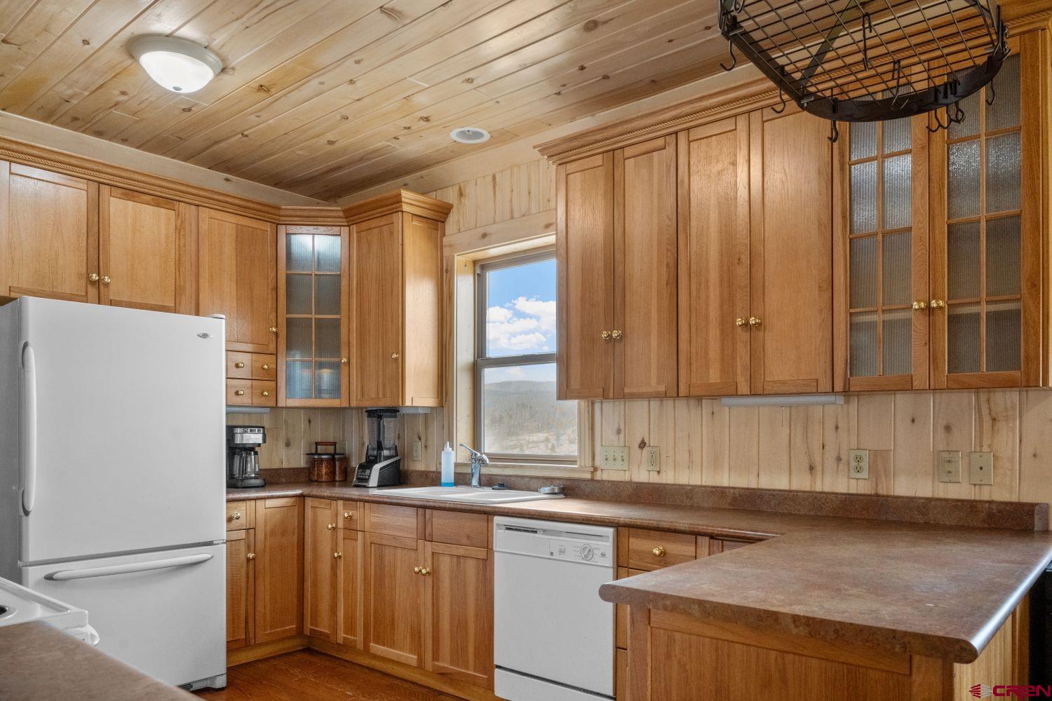 645 Emery Loop Fort Garland, CO 81133 - Photo 7 of 44 a kitchen with a refrigerator a sink and cabinets