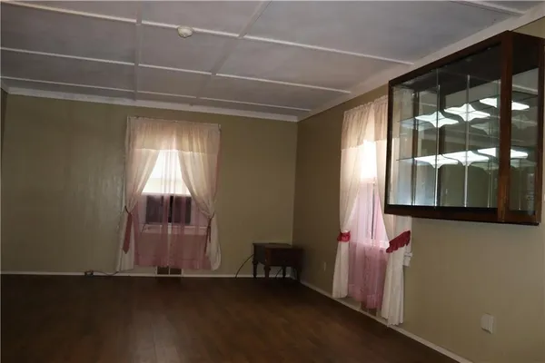 a room with wooden floor and windows