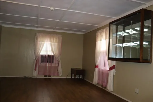 a room with wooden floor and windows