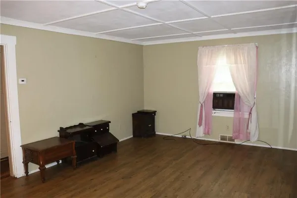 a living room with hard wood floors and a window