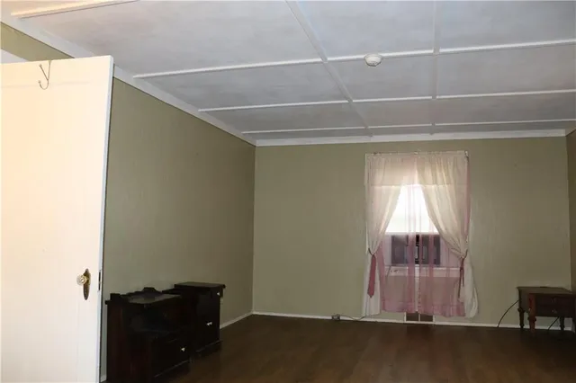 a room with a wooden floor and a window