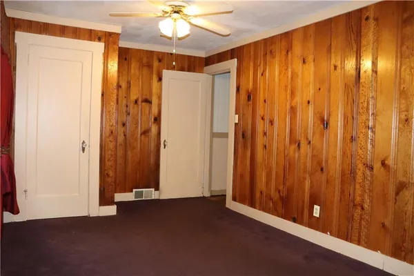 a view of a hallway with chandelier fan