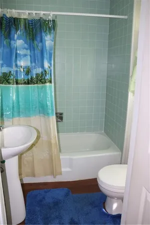 a bathroom with a sink a toilet a bathtub and shower