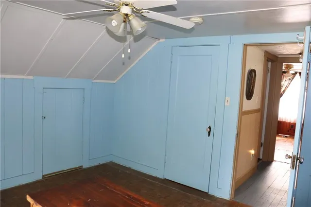 a view of a hallway with a chandelier fan and wooden floor