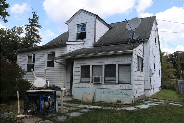 a view of a white house with a large window and a yard