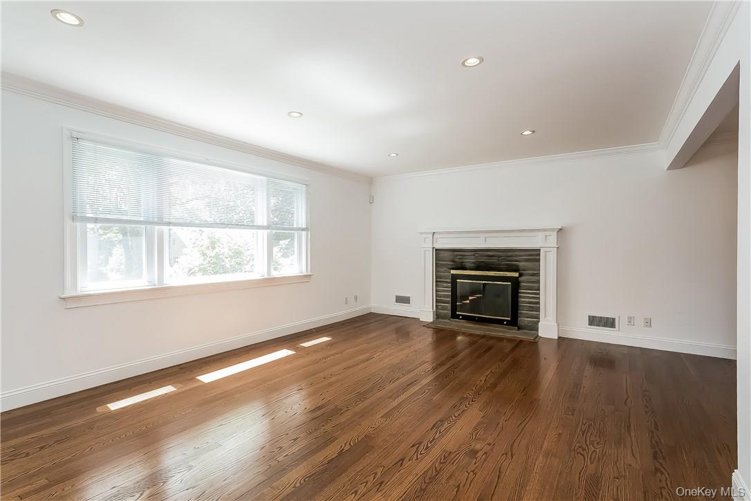 20 Walker Avenue Rye, NY 10580 - Photo 2 of 25 an empty room with wooden floor fireplace and windows