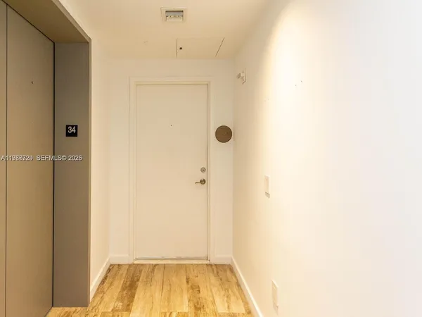 an empty room with wooden floor and sliding door